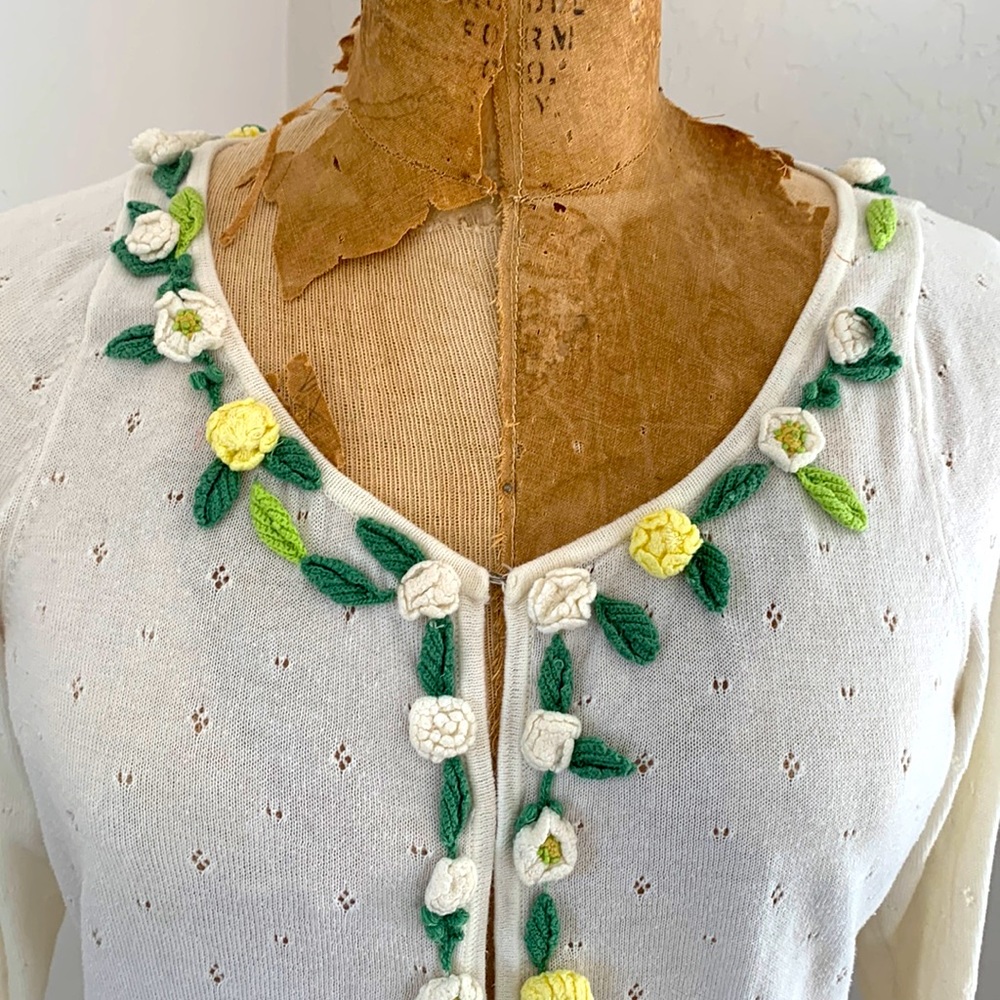 Vintage pointelle cardigan with handmade crocheted flower trimming.